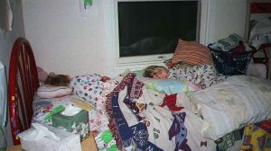 the children asleep on a bed piled high with all their blankets and pillows