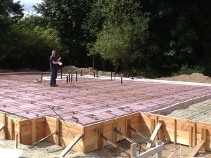 Jon, setting up the tubing.  The white lines are the radiant tubes!!!  He ties them to the wire grid that the concrete gets poured over.  It's all finally coming together.  :-D