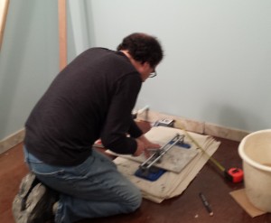 a slightly blurry image of Tom in position making straight cuts for the larger tiles.