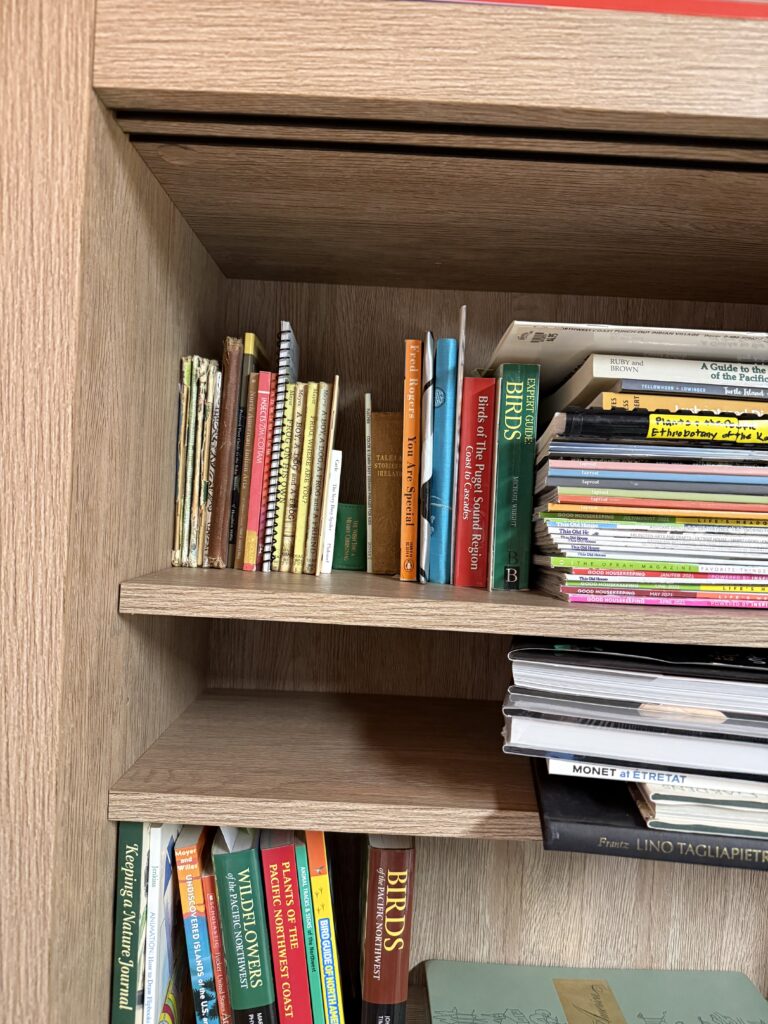 a corner of a bookcase with books stacked vertically and horizontally