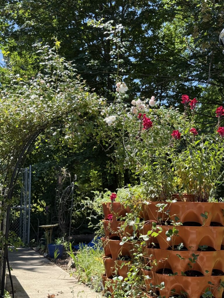 Abundance flowers and other plants in and around a potting tower.